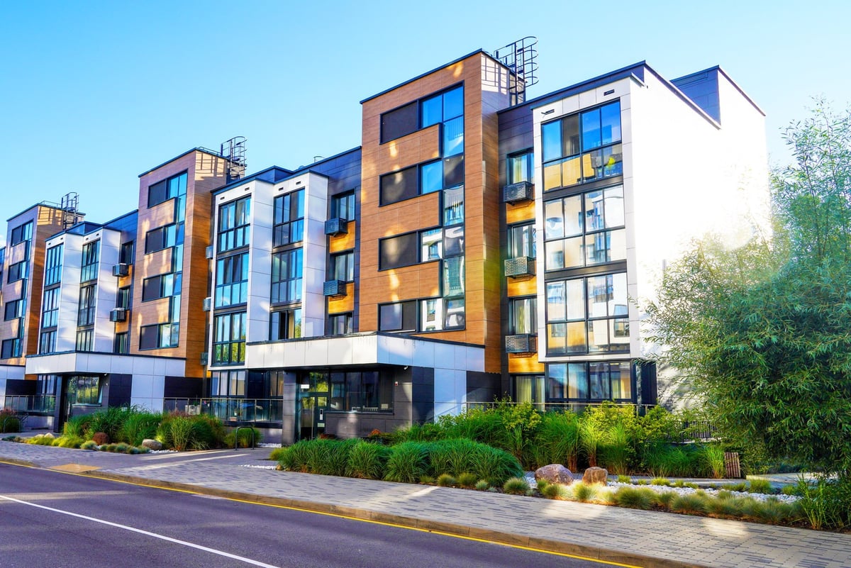 Modern residential building in contemporary architecture. Modern apartment facade in a green environment, entrance to residential building.