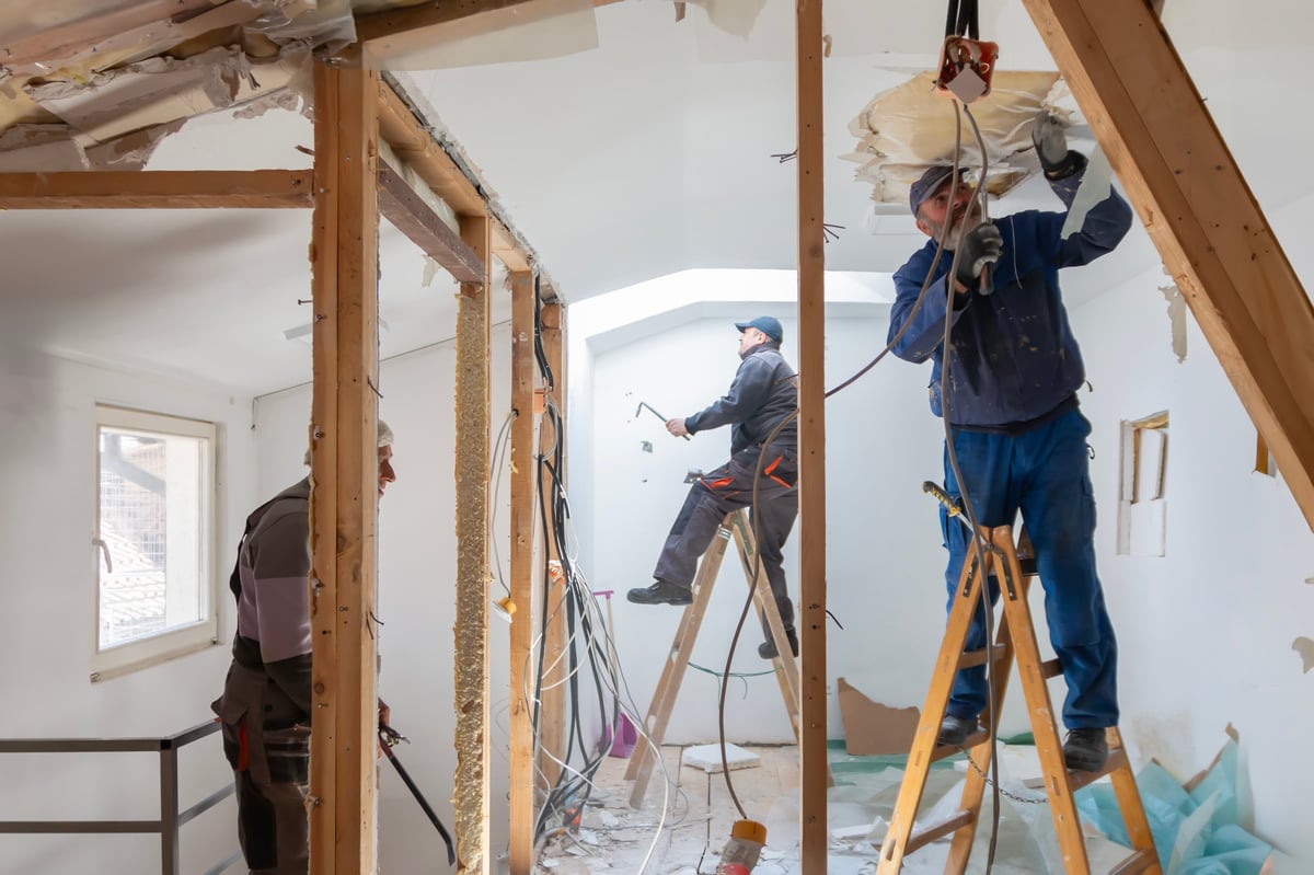Home renovation worker crew on the job. Authentic construction professional during apartment restoration.