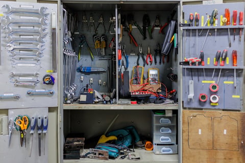 Open tool panel with hand tools like a hammer, screwdriver, and wrench, ready for apartment maintenance and repair work.