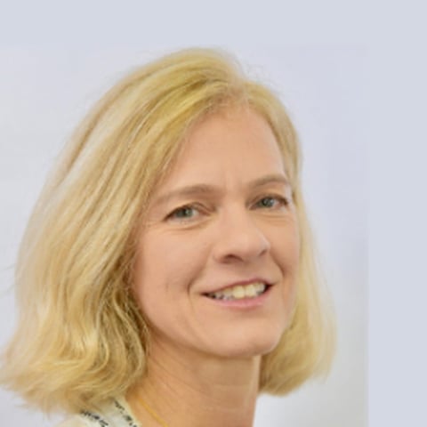 Headshot of a smiling woman with blonde shoulder-length hair against a white background